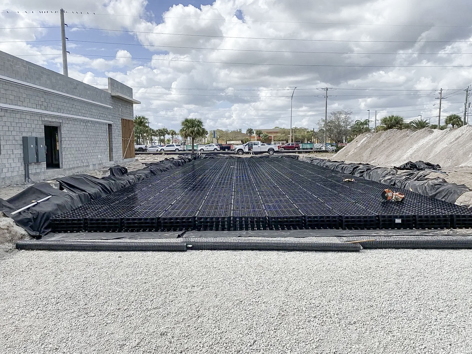 Workers installing underground stormwater structures on a commercial jobsite