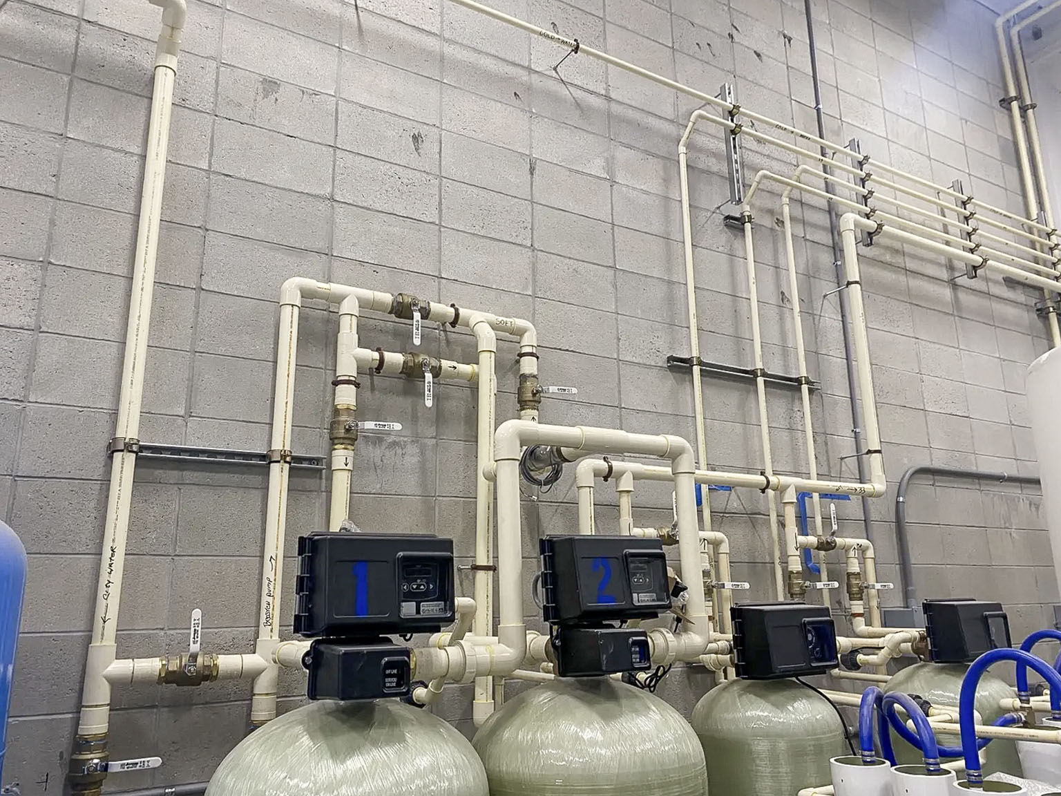 Water treatment tanks and piping inside a car wash equipment room